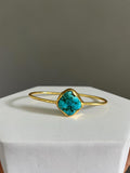Gold bracelet with a single turquoise stone 
